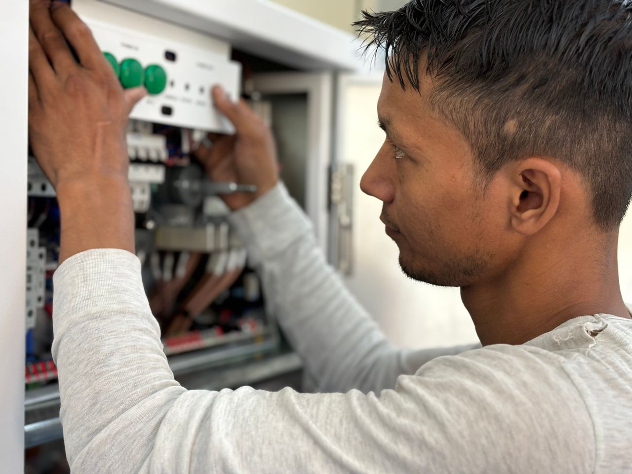 Focused electrician adjusting circuit breaker panel. Technology and skill in action.
